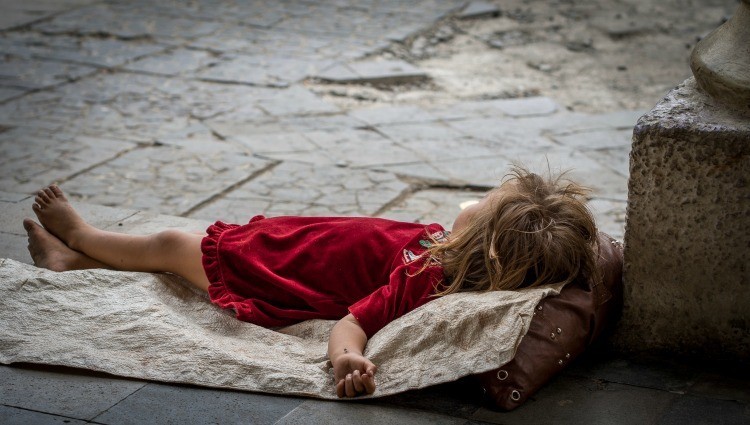 Nicaraguan girl in a red dress sleeps on the street