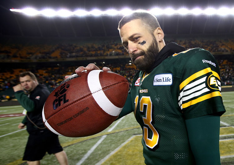 Edmonton Eskimo football player showing the ball to photographer