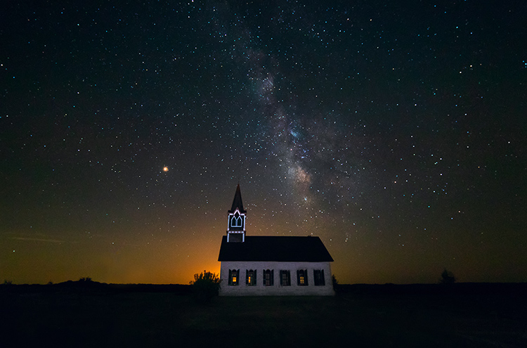 the milky way photographed over rock church