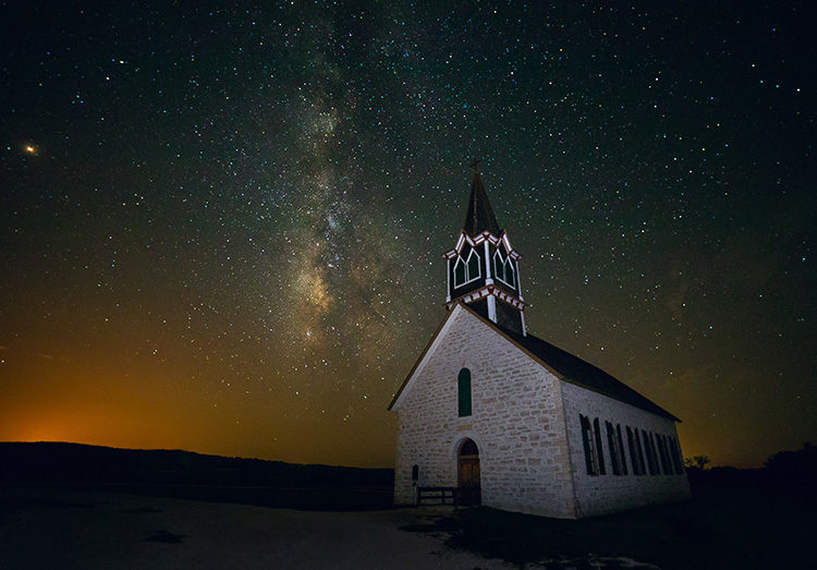 milky way photographed using an old church as foreground