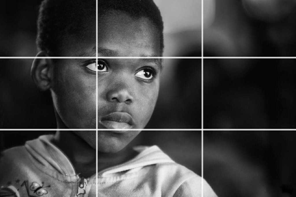 A close portrait of a child with rule of thirds grid lines superimposed.