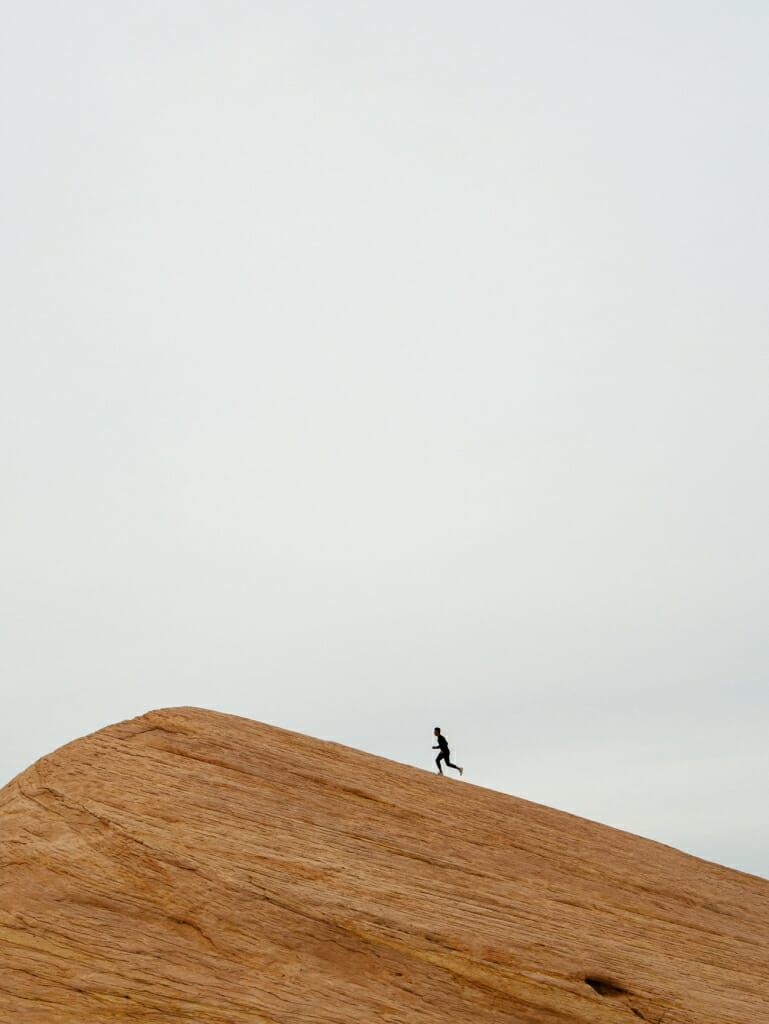 person runs up rock