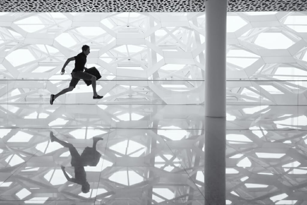 man running with briefcase into negative space