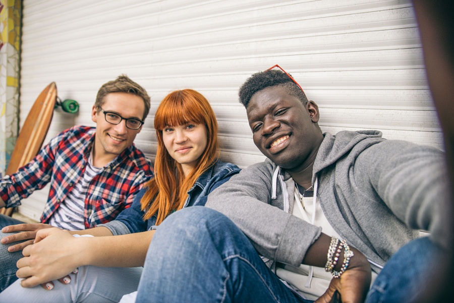 Group of friends of different ethnics taking a selfie - Young modern hipster people having fun and laughing - Multiracial group photographing themselves and looking into camera