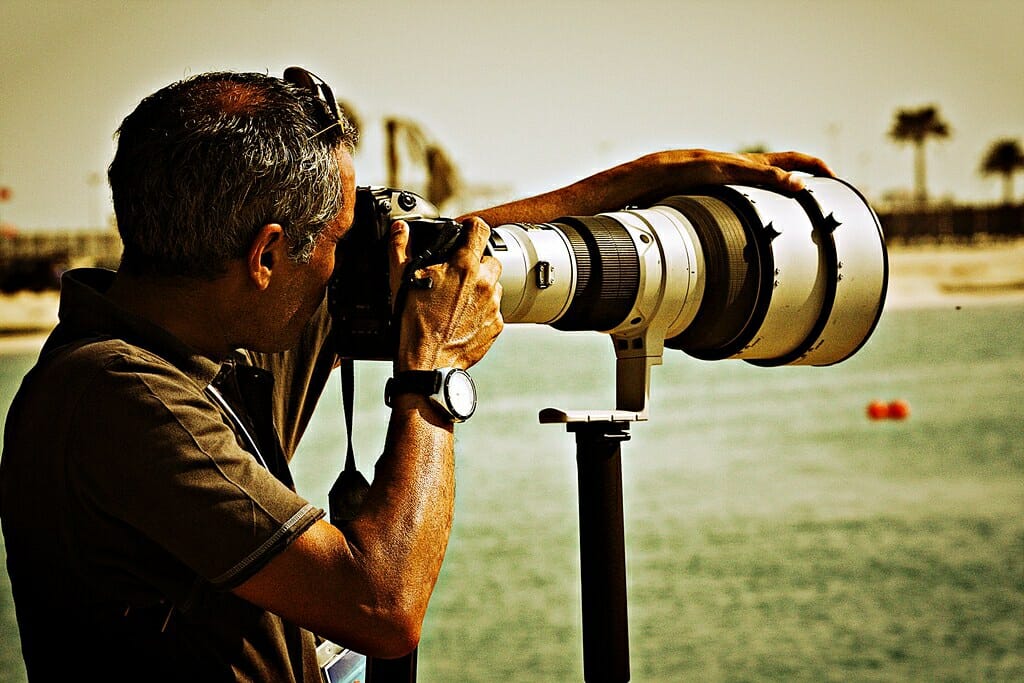 lens envy. a photographer with a huge lens.