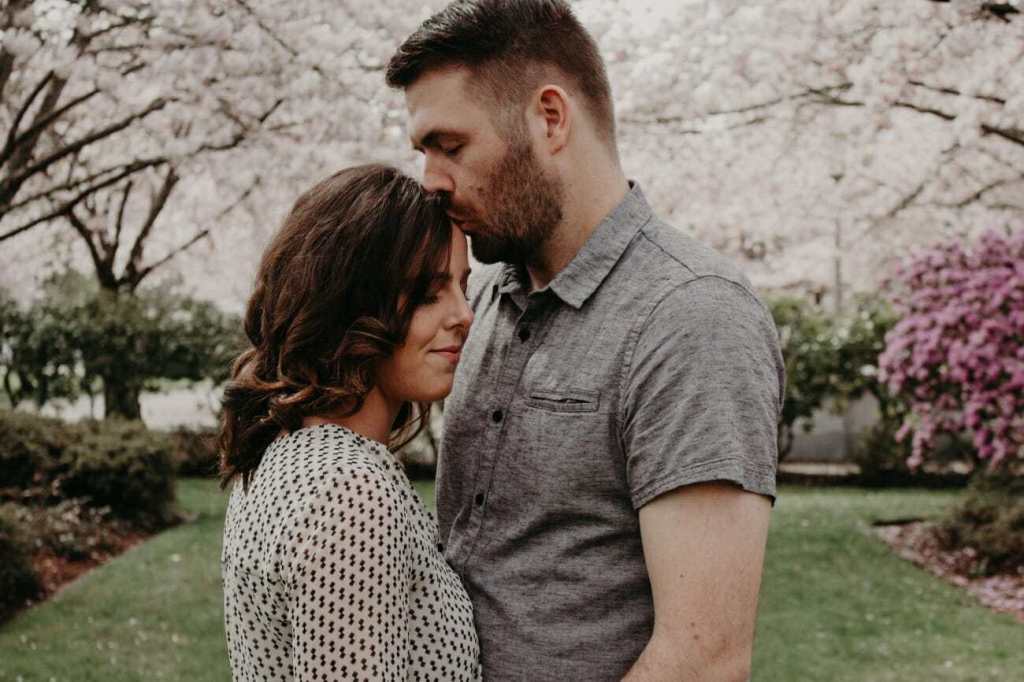 man kissing woman's head