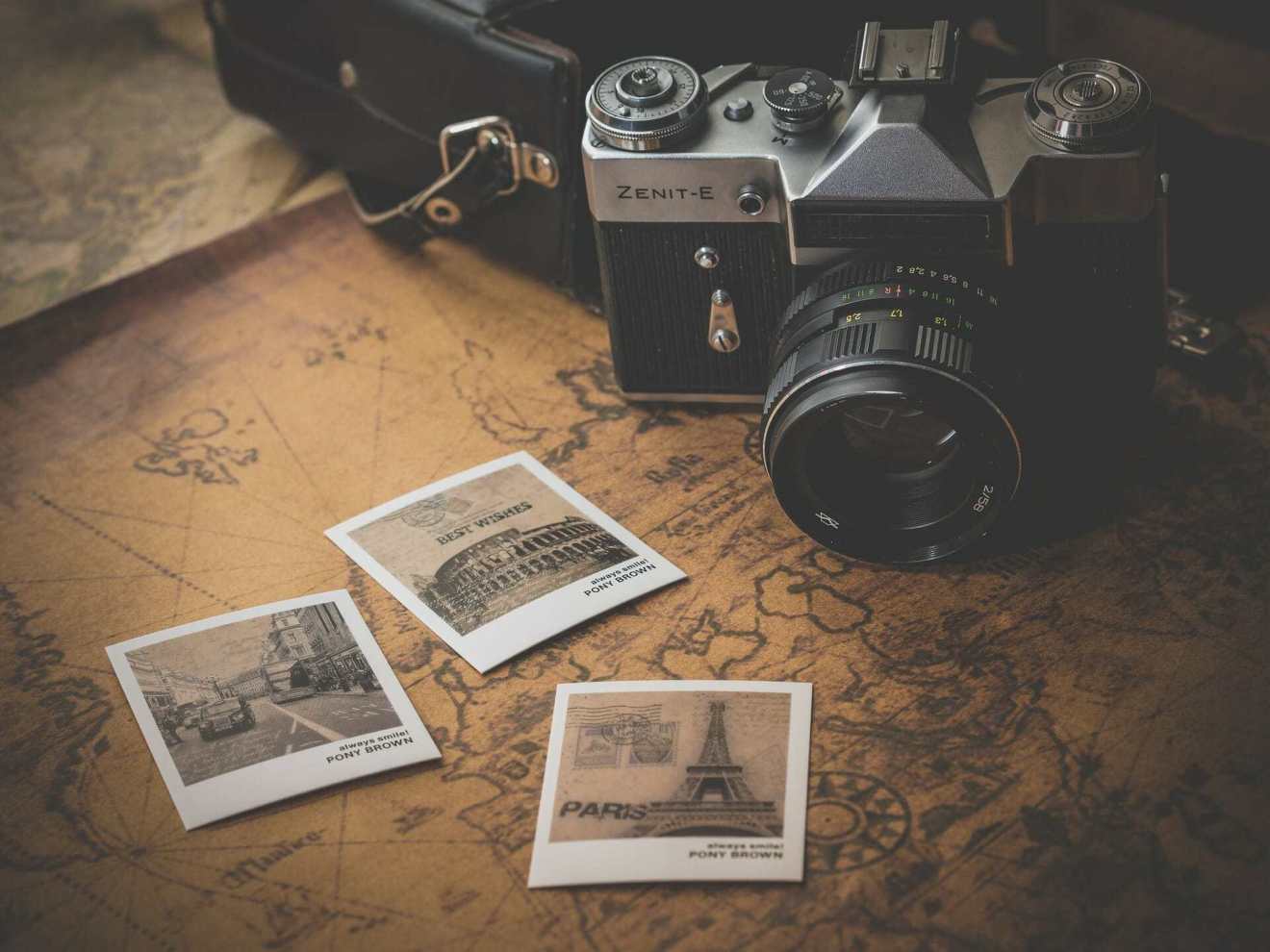 A camera with 3 printed square polaroid pictures next to it