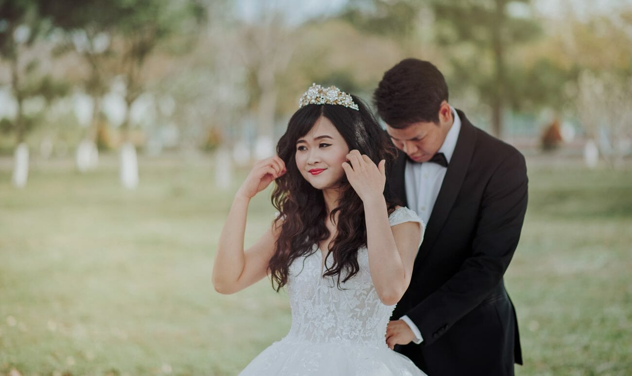 A groom helps tie the back of his bride's dress, another of the common wedding poses