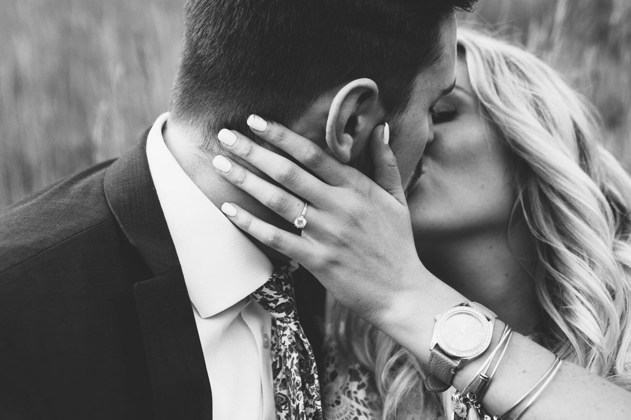 A close-up black and white image of a bride and groom kissing, one of the essential wedding poses