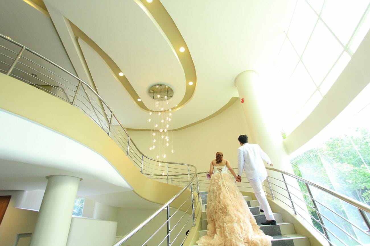 A bride and groom ascend a large staircase at the end of their wedding day, another one of the classic wedding poses