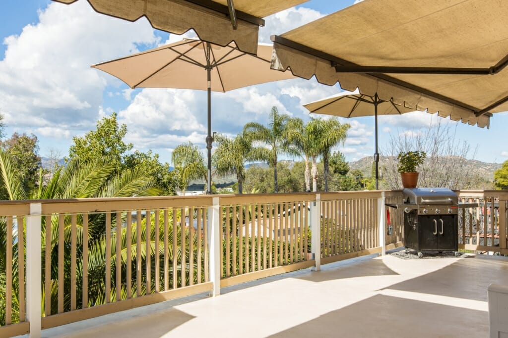 A wide angle real estate photograph of an outdoor deck area