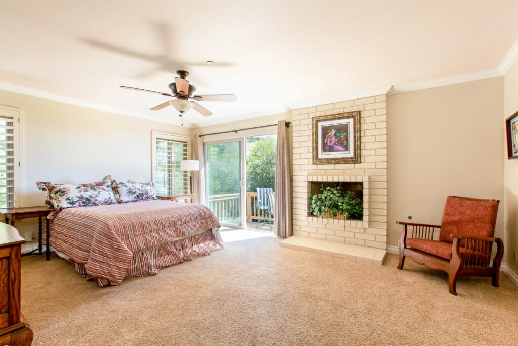 A wide angle real estate photograph of a master bedroom