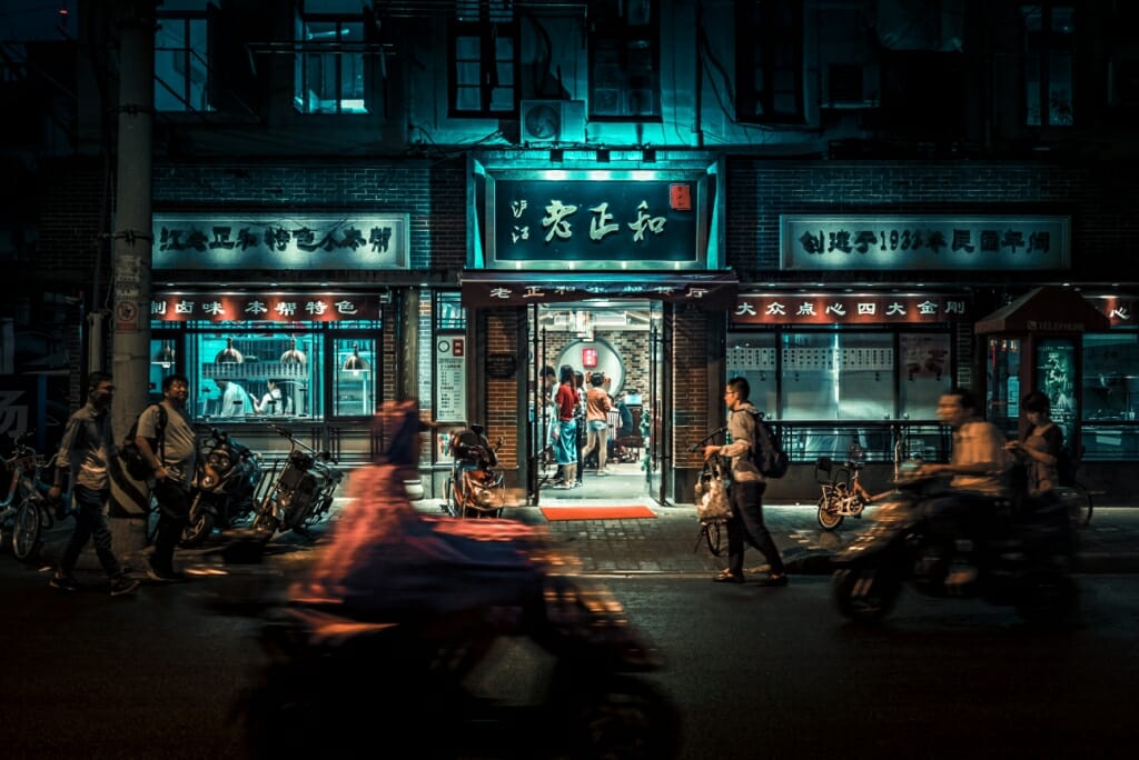 A night photograph taken in a busy street in Tokyo using a DSLR camera at high ISO settings