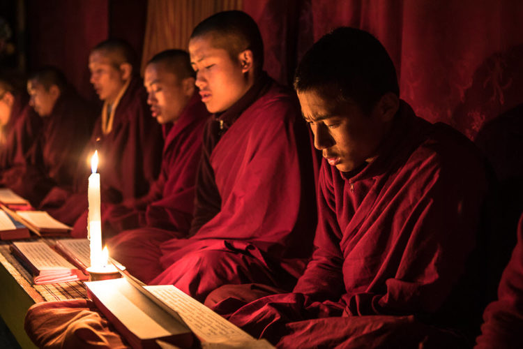 Monks dressed in traditional robes in a temple for a private photo shoot for tour guests