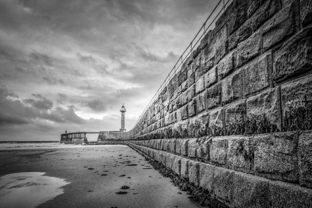 a shorewall leading up to a lighthouse. The leading line act to direct the viewer's eye to the lighthouse.