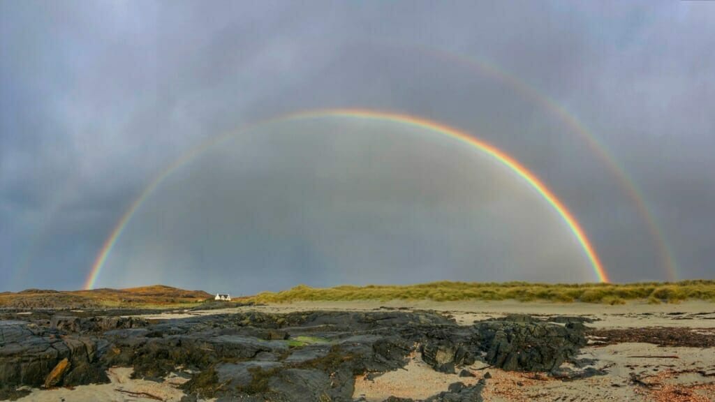 A photo of a double rainbow over fields shot on an iPhone