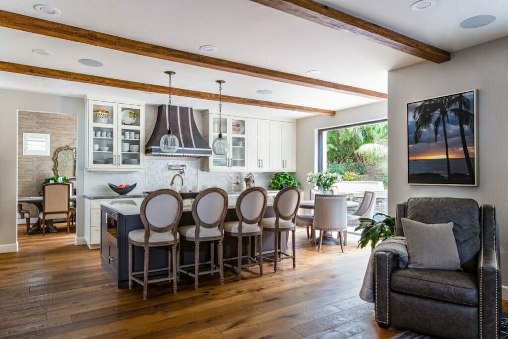 A transition shot of an adjoining kitchen, dining area and back yard