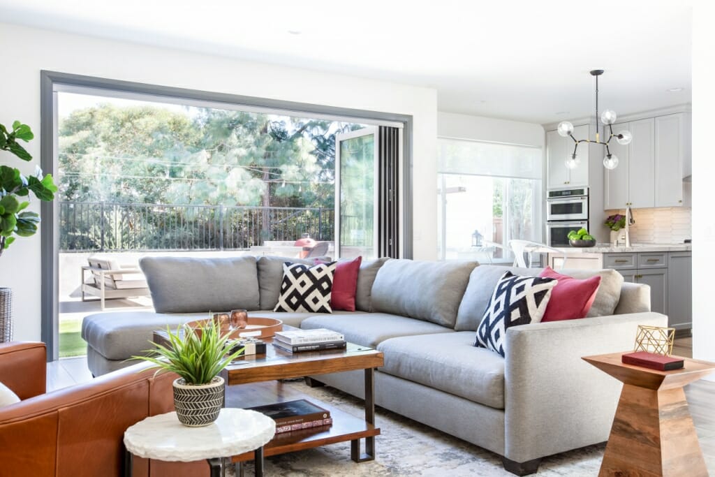An interior photography image of a spacious living room including a large, grey L-shaped sofa
