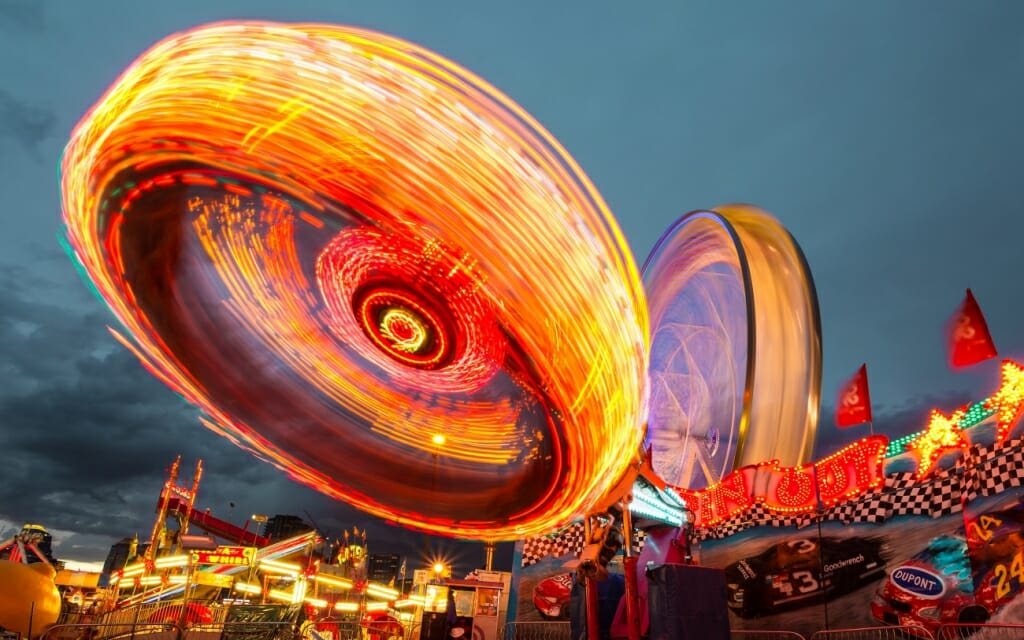 Colorful, spinning amusement park rides photographed with motion bur