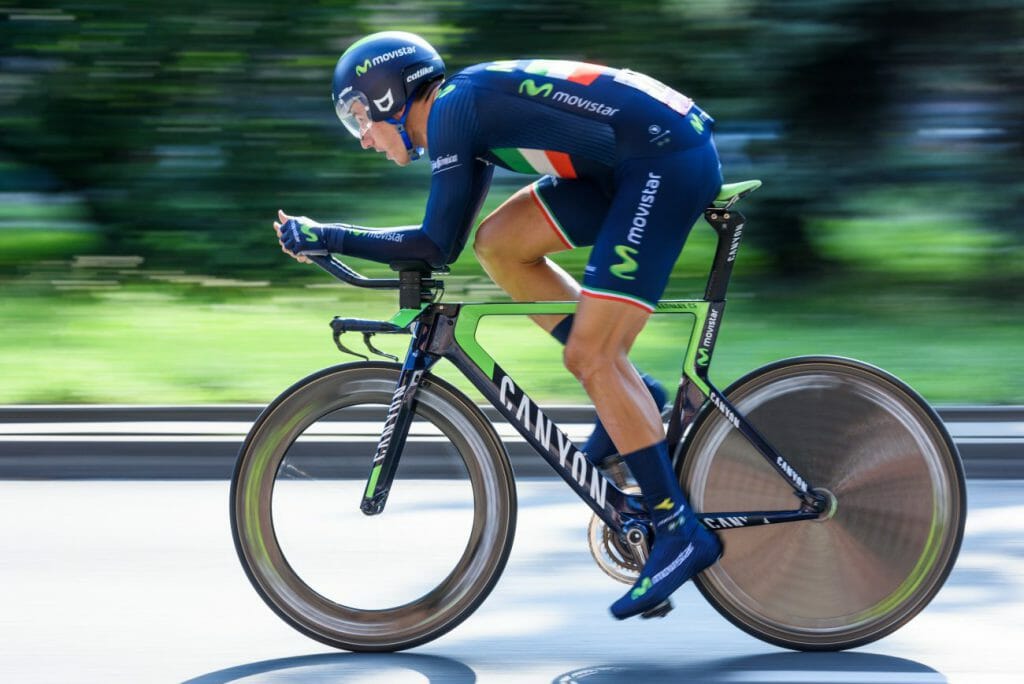 A panning shot to create motion blur around a cyclist racing down a road