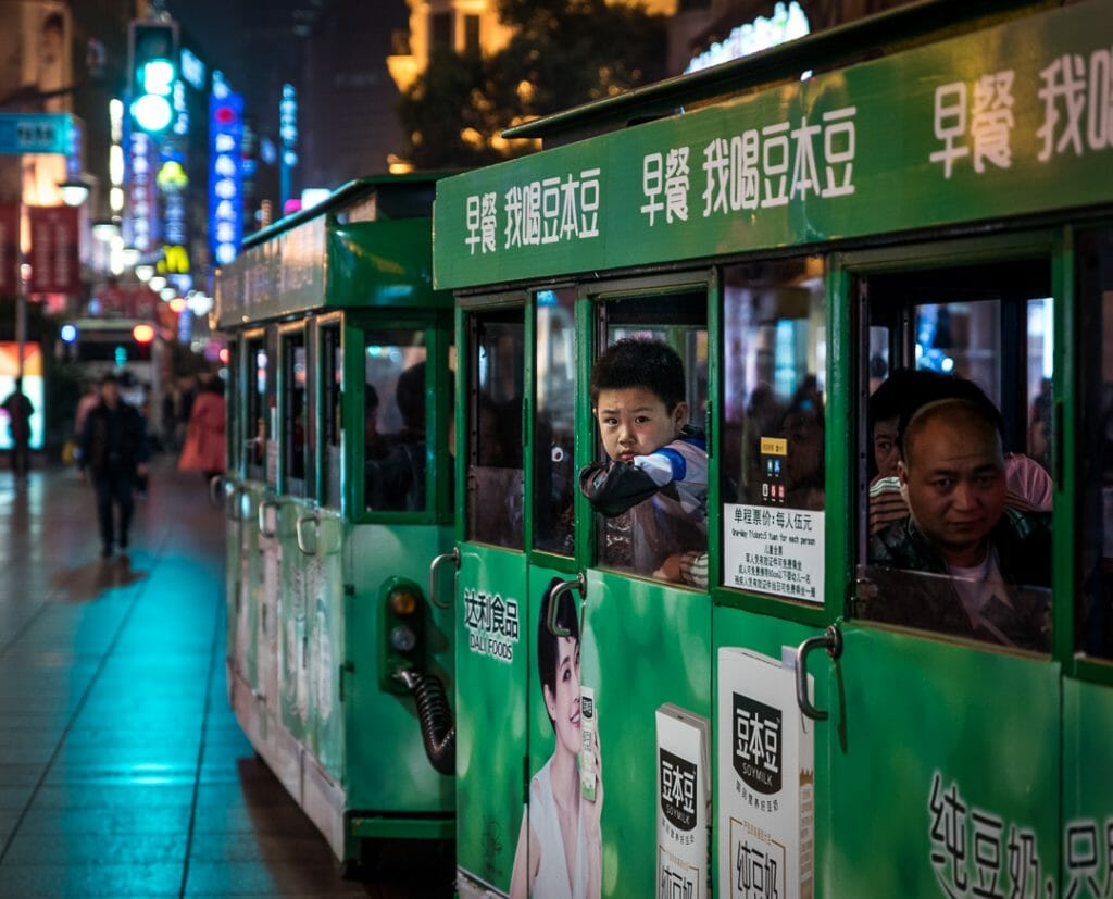 A boy looks out the window of a tourist train on Nanjing road in Shanghai