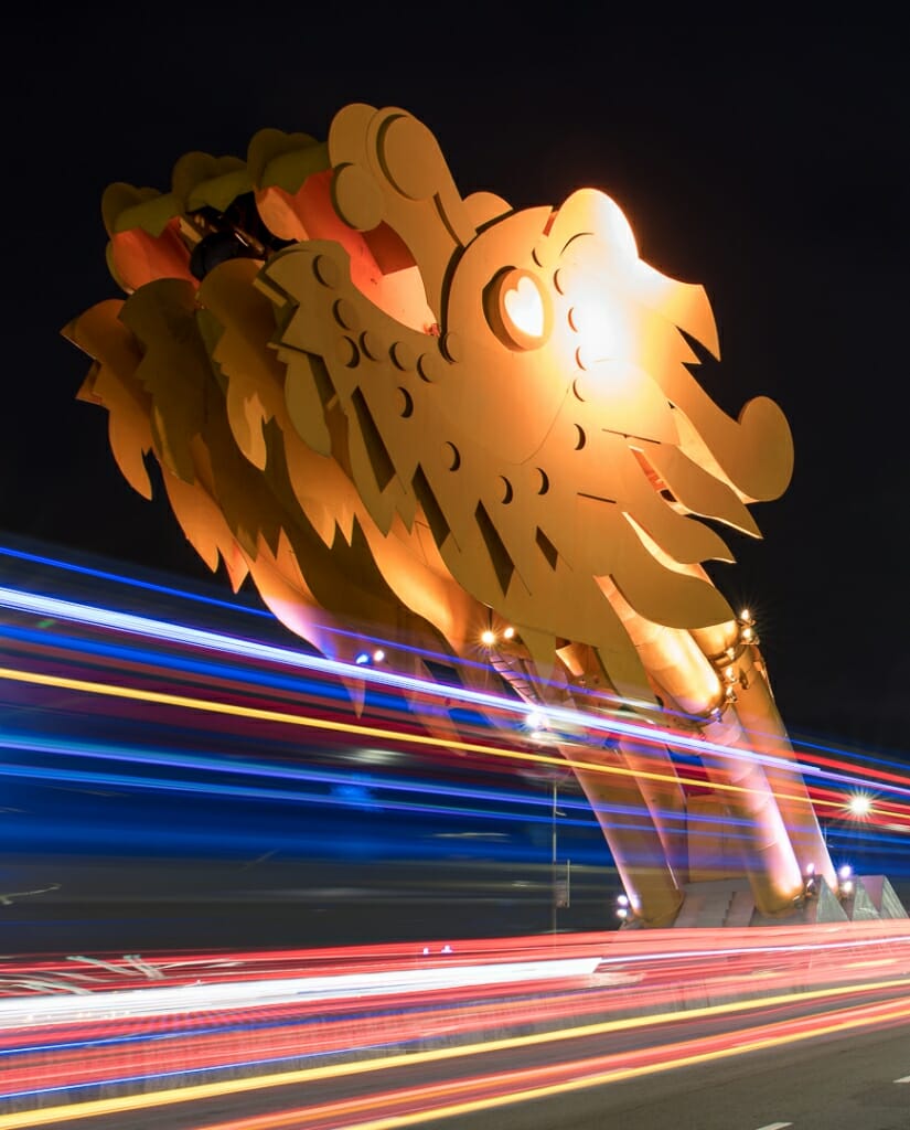 Light trails from traffic underline the head of the dragon on Dragon Bridge in Da Nang, Vietnam