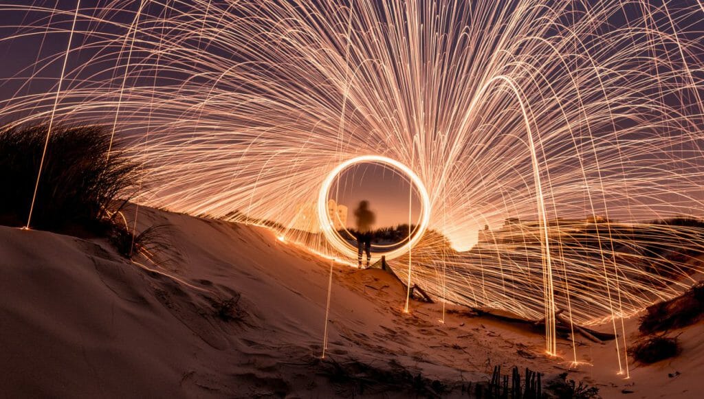 Steel wool set alight and spun around on a wire, creating arcs of light during a long exposure