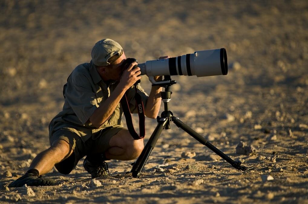 A wildlife photographer with a tripod