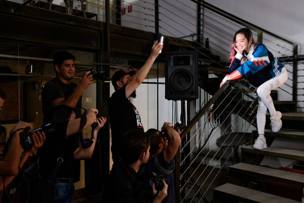 A group of photographers take photos of a model sat on a staircase, a great photography marketing tool