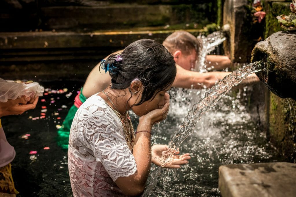 A travel photography image of people taking part in a bathing ritual in Bali