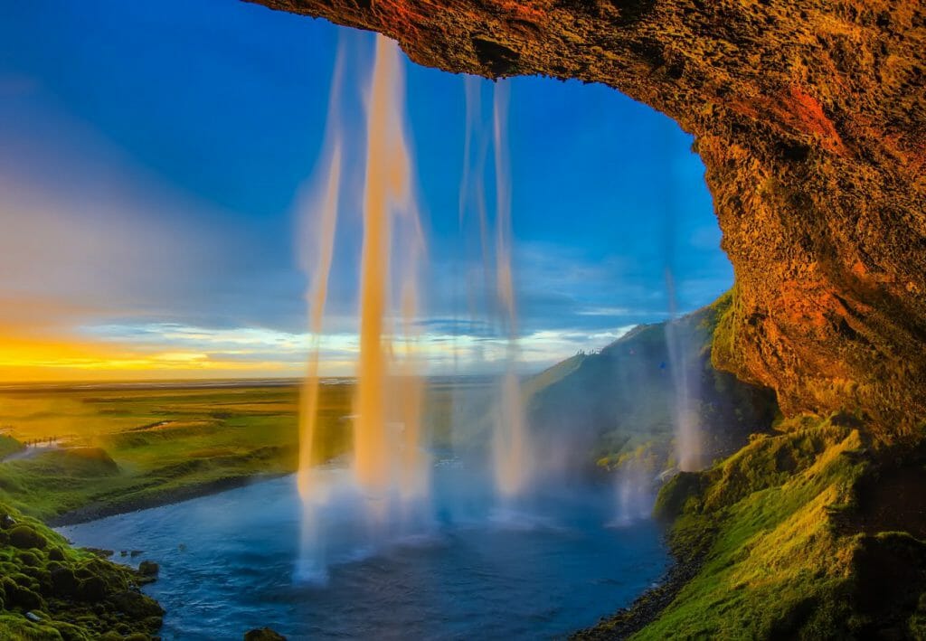 A view from a cliff-face waterfall from behind the water