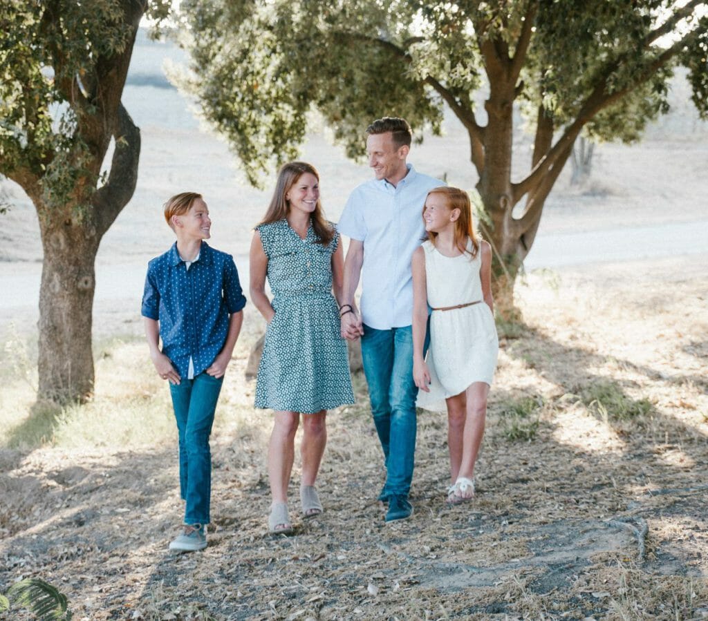 A family photograph with 4 members wearing matching color tones.