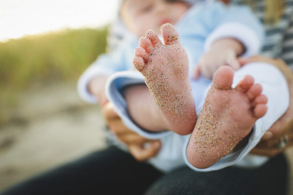 A child posing during a family photography session in a beach.