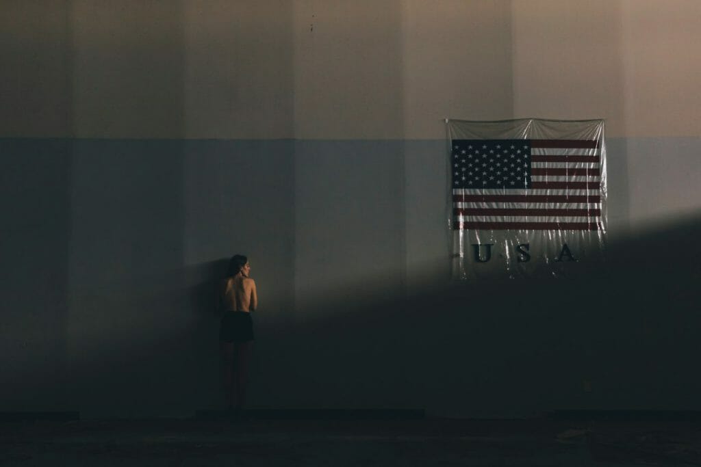 Indoor photograph of a girl facing a shadow filles wall.