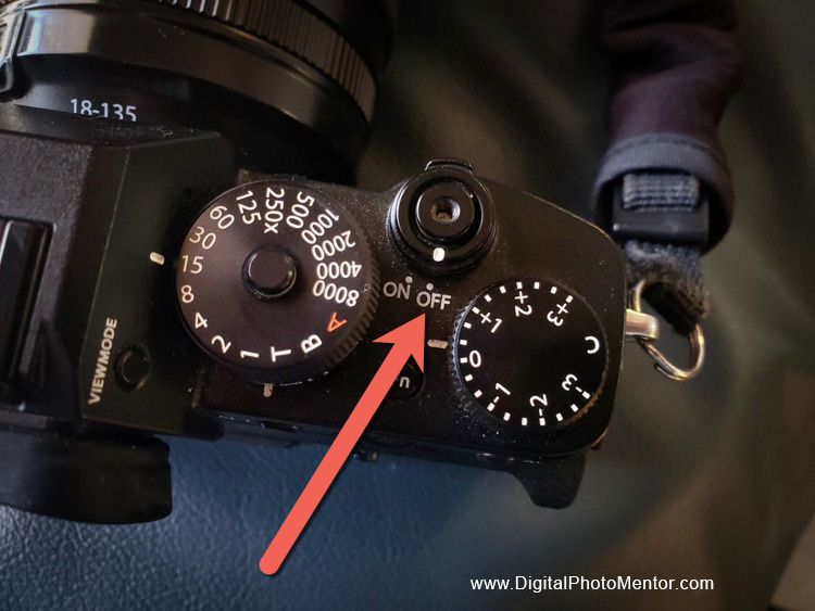 Camera on and off buttons on top of camera as indicated by arrow