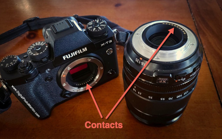 contact points on camera body and lens as indicated by arrow. Set lens with contacts up so they are not damaged