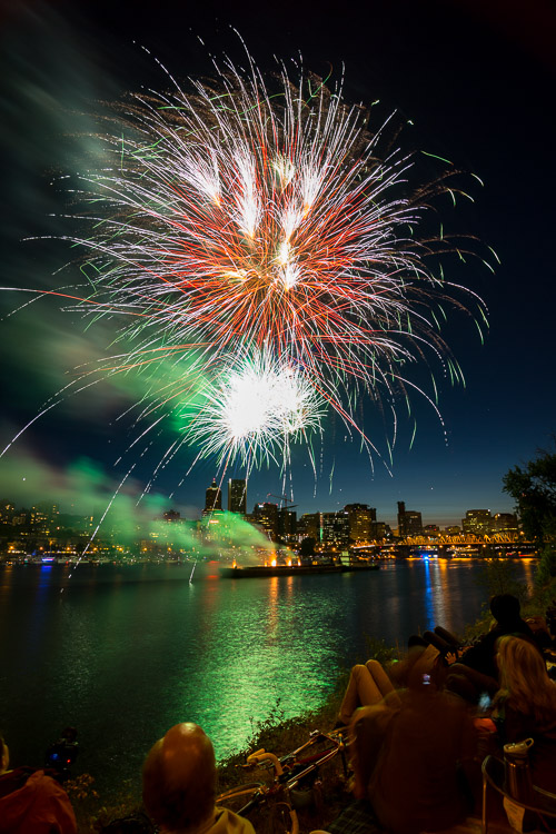 fireworks captured bursting over water and then streaking through the night sky camera settings 17mm lens, ISO 100, f/8.0, 8 second exposure