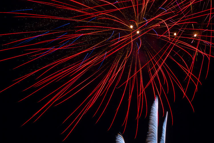 tight shot of red fireworks star burst overhead shot horizontally