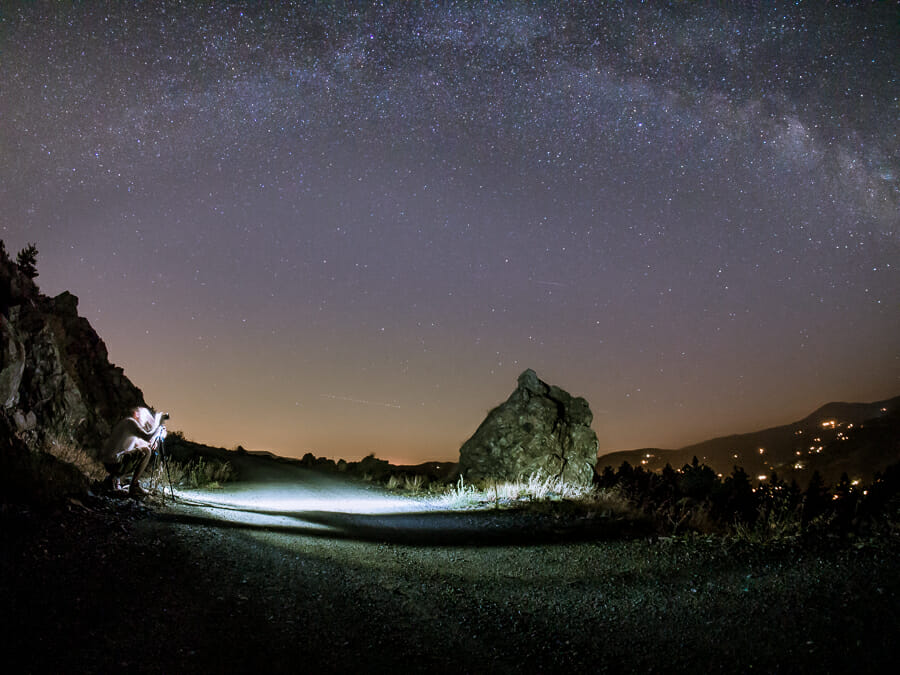 A night landscape showing stars and a person in the foreground