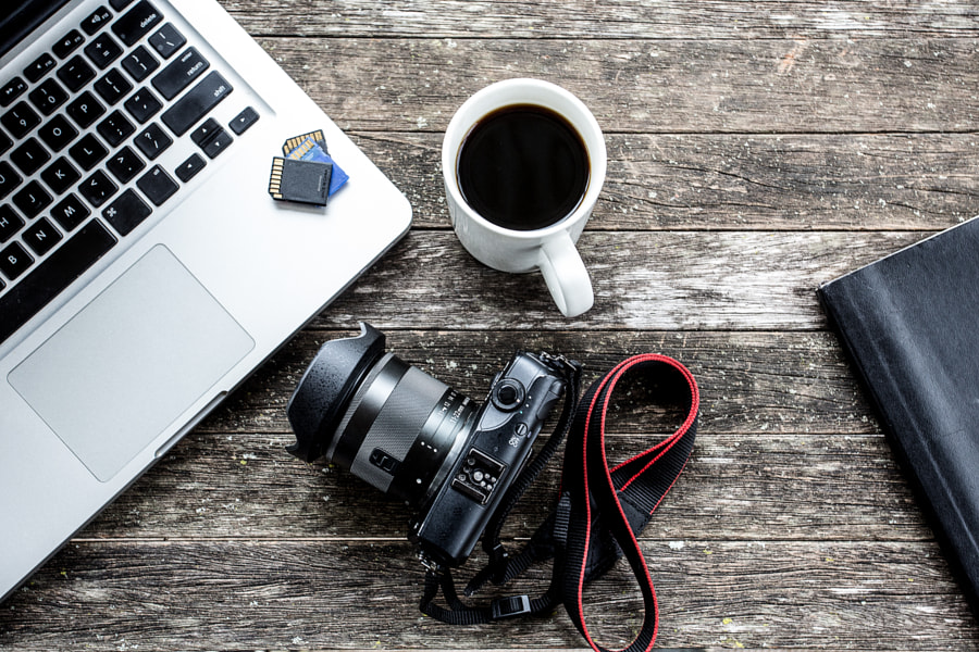Laptop with digital camera and a coffee cup. by Benjamin King on 500px.com