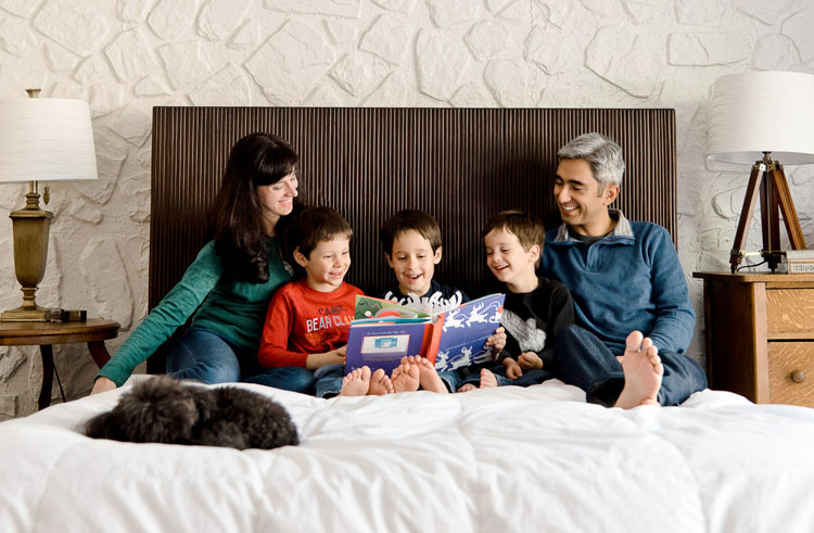 self portrait of family in bed reading books to the kids